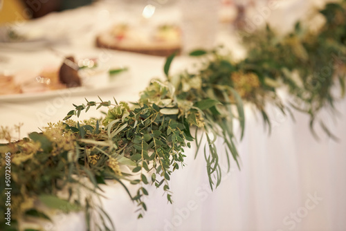 wedding table decoration with green tree branches and flowers. newlyweds wedding table decor
