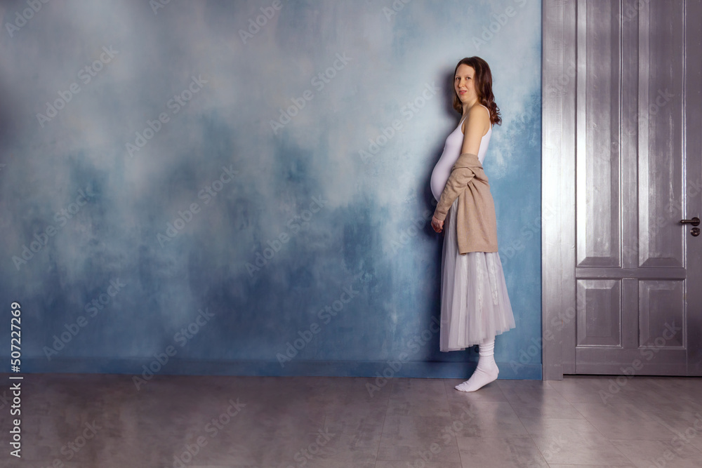 Pregnant woman dancer. Blue wall. Copy space. Pregnant woman dancer. Blue wall. Copy space.
