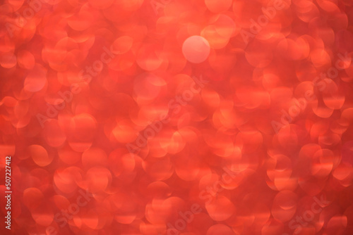 Red bokeh background. Festive Christmas shiny background. Glittering red light.