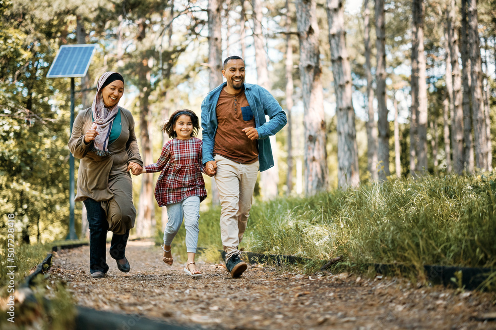 Playful Muslim family has fun while holding hands and running in nature. Playful Muslim family has fun while holding hands and running in nature.
