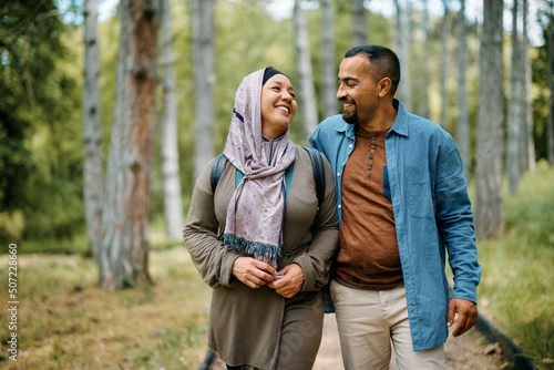 Happy Muslim couple talking while enjoying in walk in nature. © Drazen
