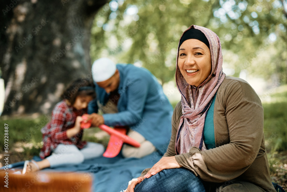 Happy Middle Eastern woman enjoys in picnic day with her family.