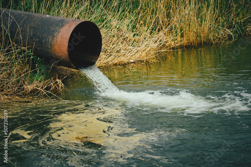 Fotografia Draining sewage from pipe into river, pollution rivers and ecology