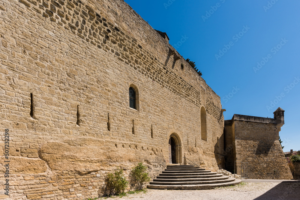 Entrance view of the historic fortified Saint Martin church in the picturesque village of Ansouis in Vaucluse, France. - obrazy, fototapety, plakaty 