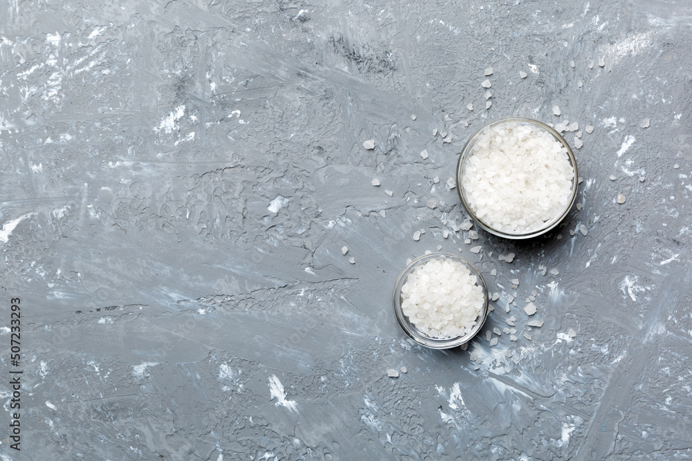 A wooden bowl of salt crystals on a wooden background. Salt in rustic bowls, top view with copy space A wooden bowl of salt crystals on a wooden background. Salt in rustic bowls, top view with copy space