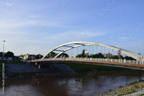 The bridge over the river is a steel frame.