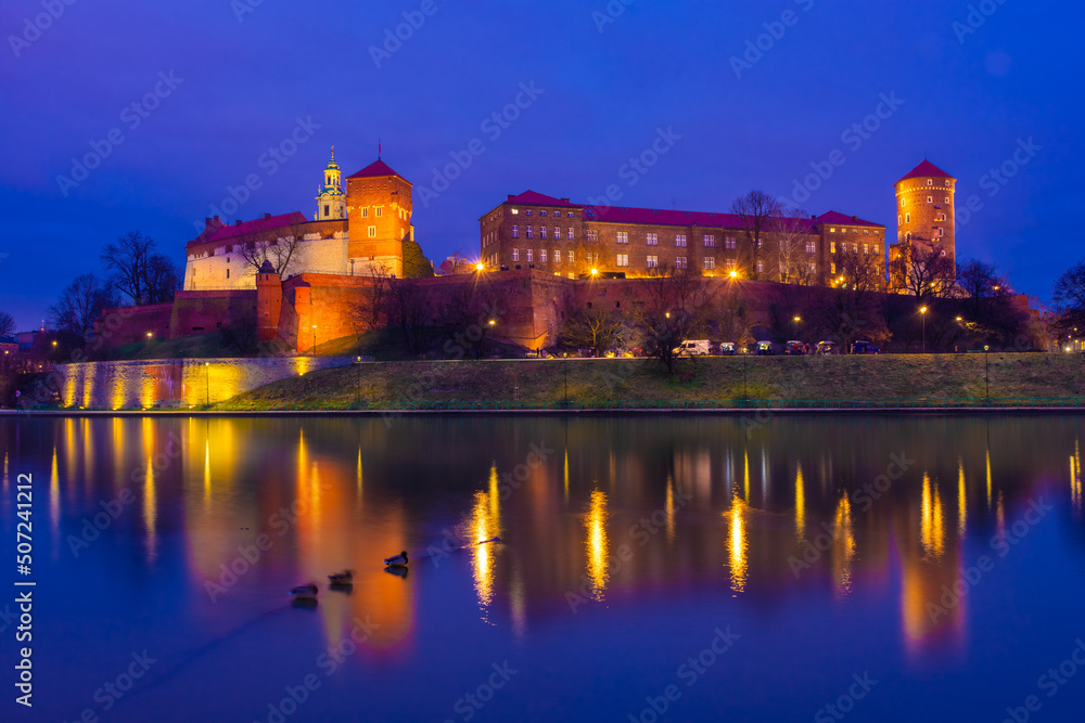 The Wawel Castle of Krakow illuminated at night, reflected on the Vistula River,  Poland