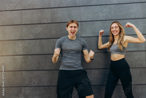 Young couple wearing sportswear standing on wall outdoors celebrating crazy and amazed for success with arms raised and open eyes screaming excited. winner concept