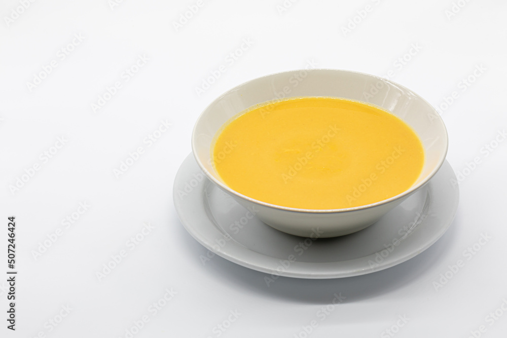 pumpkin and carrot cream with toasted bread in a ceramic bowl isolated on a white background pumpkin and carrot cream with toasted bread in a ceramic bowl isolated on a white background