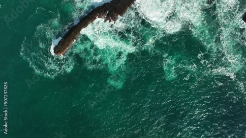 Portmagee Cliffs, Kerry, Ireland, March 2022. Drone in Bird's eye view pushes northwest along the rugged coastline as waves crash against the rocks on the Iveragh Peninsula. photo