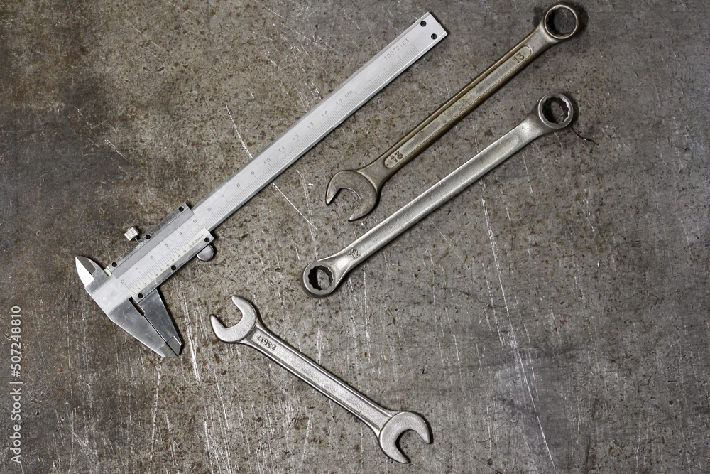 Top view of metal tools, wrenches and spanner on the background of old surface Top view of metal tools, wrenches and spanner on the background of old surface