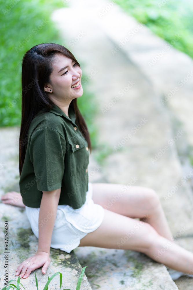a portrait of beautiful happy asian woman traveler wearing brownish green dress stylish hipster Summer sunny lifestyle on the street outdoors at sunny summer day in park background