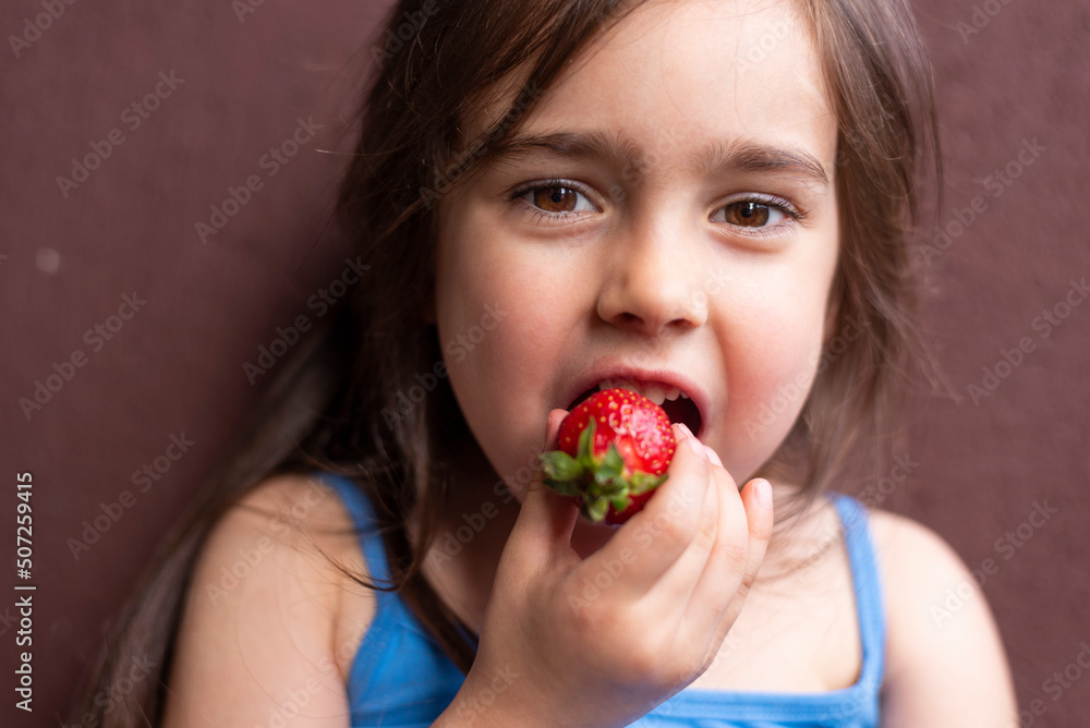 Young girl eats fresh red strawberry Young girl eats fresh red strawberry