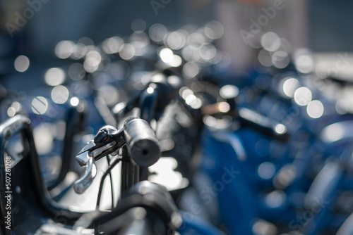 Lenker eines Fahrrads und im Hintergrund viele blaue Fahrräder 