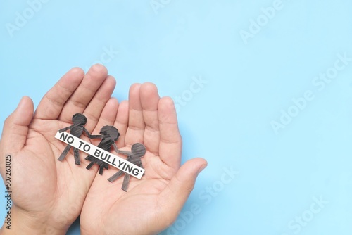 Anti-bullying and stop child bullying concept. Hand holding children with No To Bullying message. Top view with copy space.