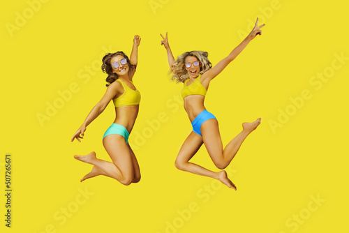 two happy girls jumping in bikini - colorful outdoors vacation