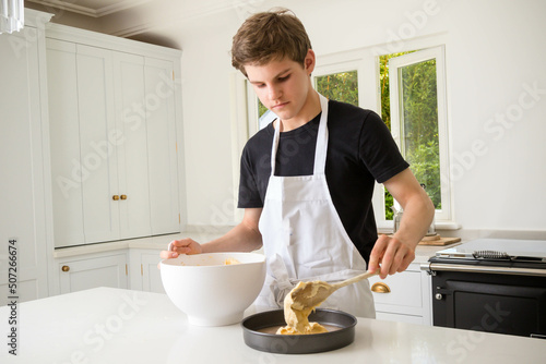 A Teenage Boy Cooking In A Kitchen