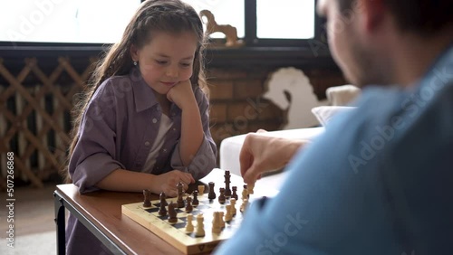 Daughter and Father Playing Chess at Home Family Time Teaching How to Play Chess.