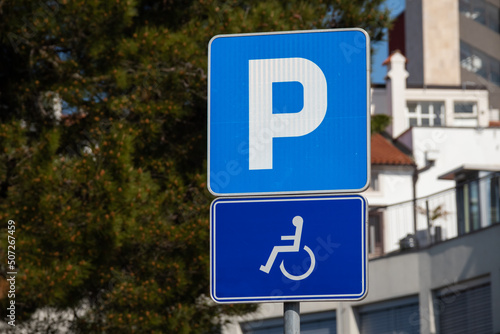 Parking spot for persons with disability with wheelchair sign.