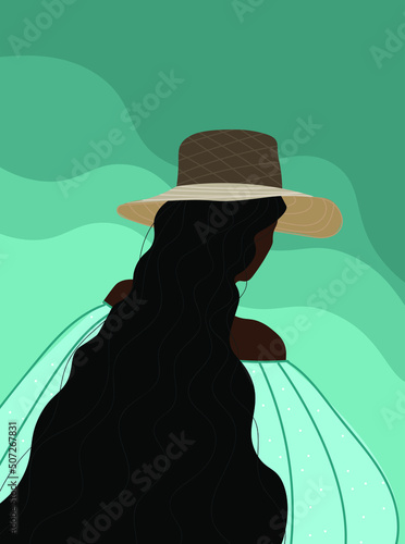 A view from the back of a girl with dark hair, wearing a straw hat, standing next to the seashore.