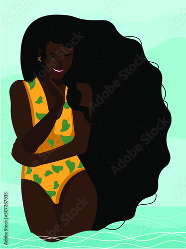 A girl with loose long hair, in a yellow swimsuit, stands knee-deep in the sea and smiles.