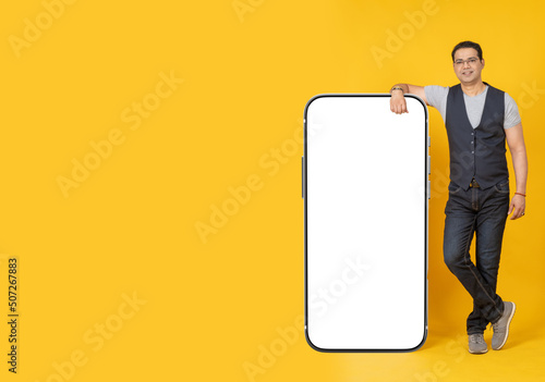 A man with a big phone. Place for the inscription on the phone monitor. A smartphone with an empty white screen. The man holds a large smartphone. A person shows a screen with a place for the inscript photo