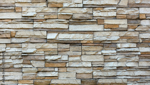 Closeup outdoor wall made of wild stone in beige color.