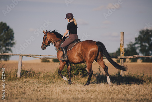 Uśmiechnięta dziewczyna jeździec konny na koniu na letnim polu  © KacperSalamon
