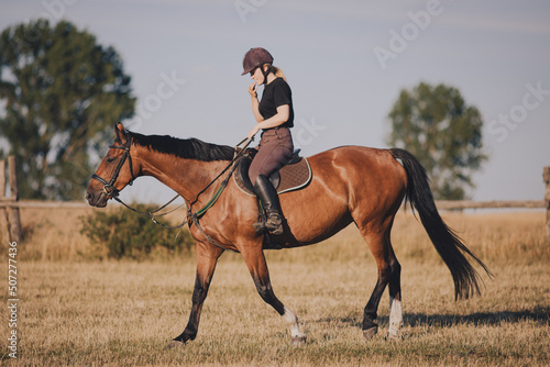 Uśmiechnięta dziewczyna jeździec konny na koniu na letnim polu  © KacperSalamon