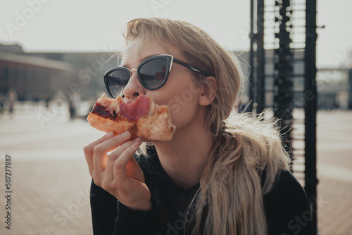 Dziewczyna w okularach jedząca Pizzę na dworzu