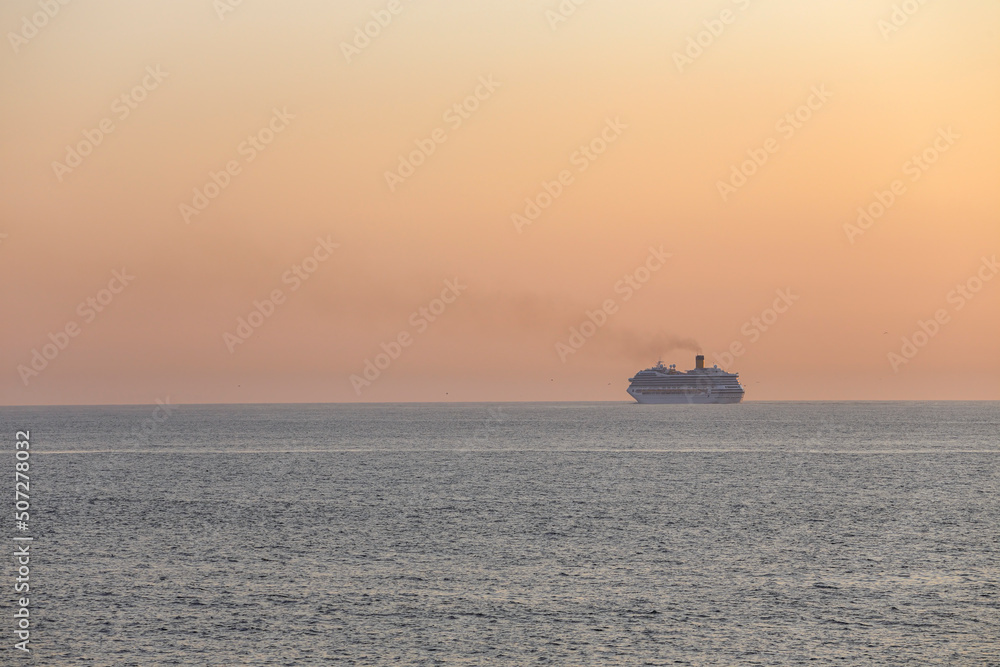Passenger ship crossing the sea at sunset