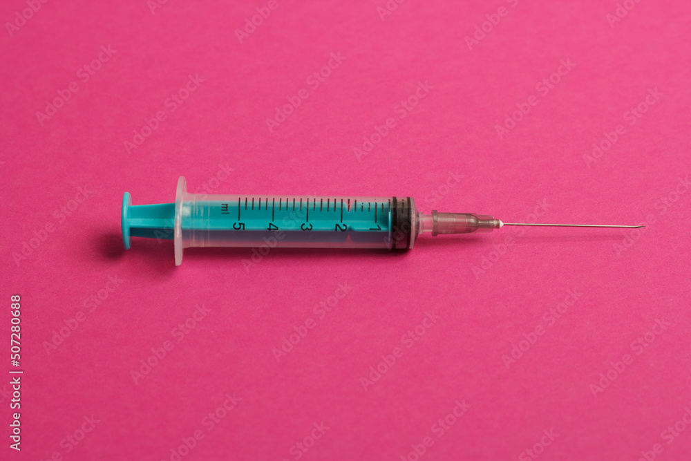 Medical syringe on a pink background. A syringe for injection. The concept of health and beauty Medical syringe on a pink background. A syringe for injection. The concept of health and beauty