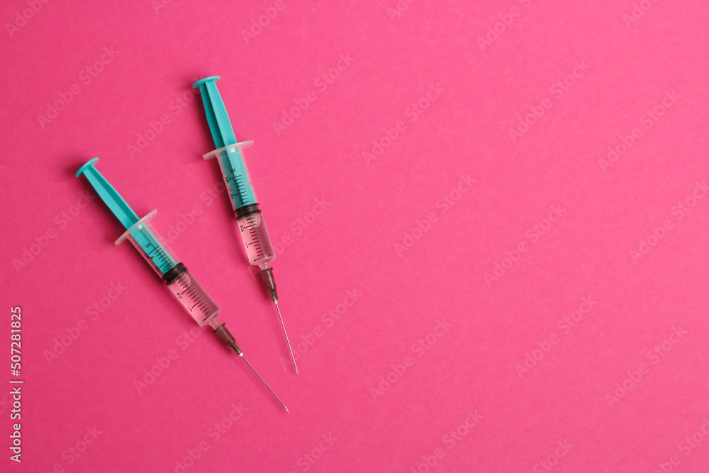 Medical syringe on a pink background. A syringe for injection. The concept of health and beauty Medical syringe on a pink background. A syringe for injection. The concept of health and beauty