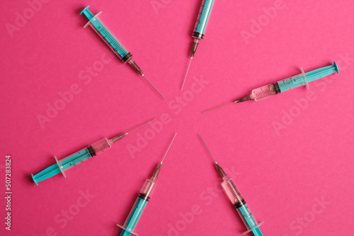 Medical syringe on a pink background. A syringe for injection. The concept of health and beauty