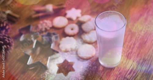 Image of light spots over milk and cookies at christmas