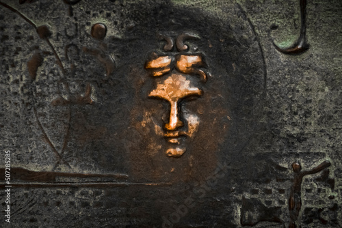 Canvas Print close-up of a bronze sculpture depicting the face of a woman on the entrance doo