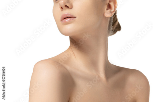 Cropped image of slim, tender woman's neck and shoulders isolated over white studio background. Female natural beauty concept
