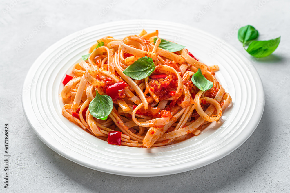 Italian linguini pasta with tomato sauce and fresh basil close-up. Italian food. Side view. Italian linguini pasta with tomato sauce and fresh basil close-up. Italian food. Side view.