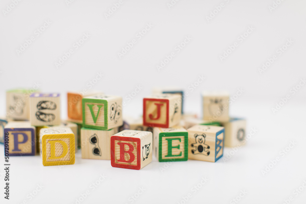 A pile of children painted alphabet wooden blocks isolated with white background for text copy space. A pile of children painted alphabet wooden blocks isolated with white background for text copy space.