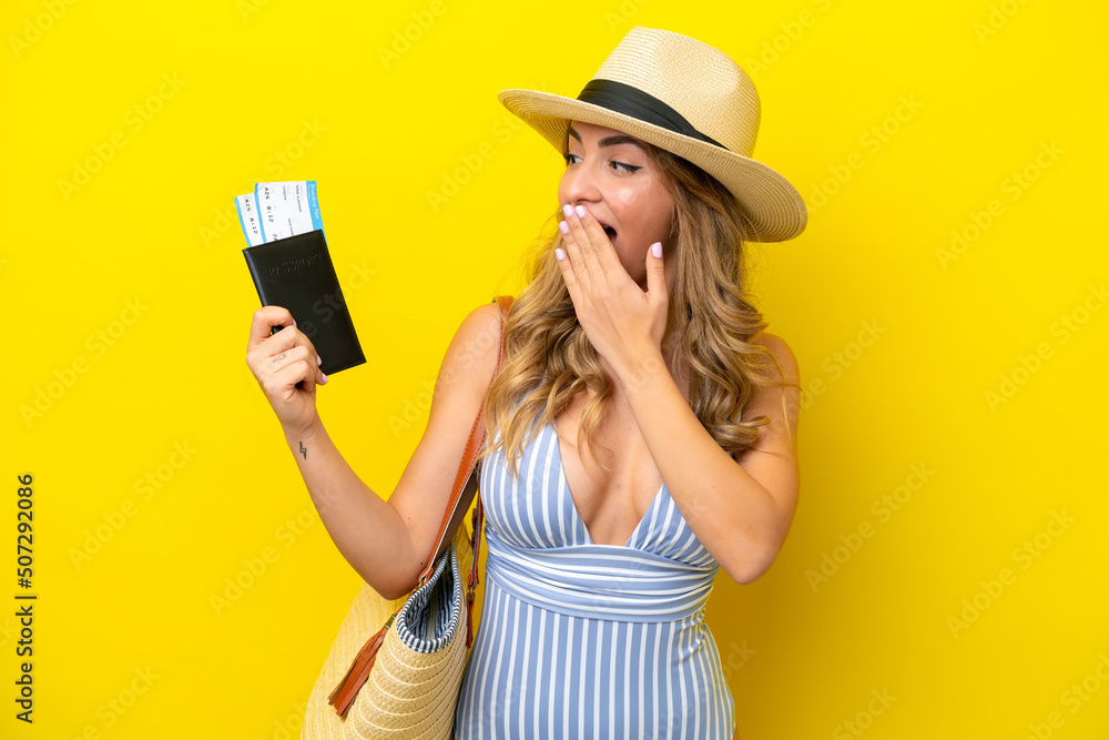 Young woman goes on vacation to the beach isolated on yellow background with surprise and shocked facial expression Young woman goes on vacation to the beach isolated on yellow background with surprise and shocked facial expression
