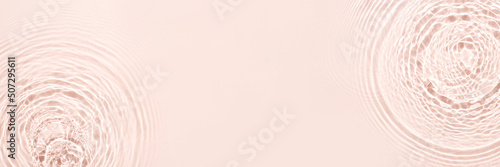 The texture of water on a pink background in bright sunlight.