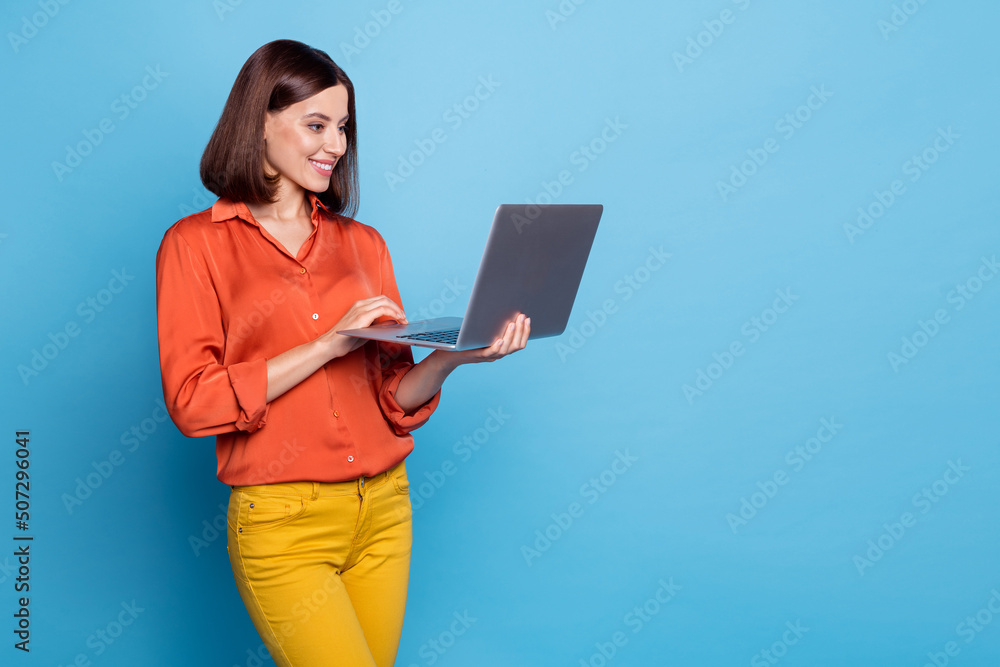 Portrait of attractive cheerful focused girl using laptop copy blank space isolated over bright blue color background Portrait of attractive cheerful focused girl using laptop copy blank space isolated over bright blue color background