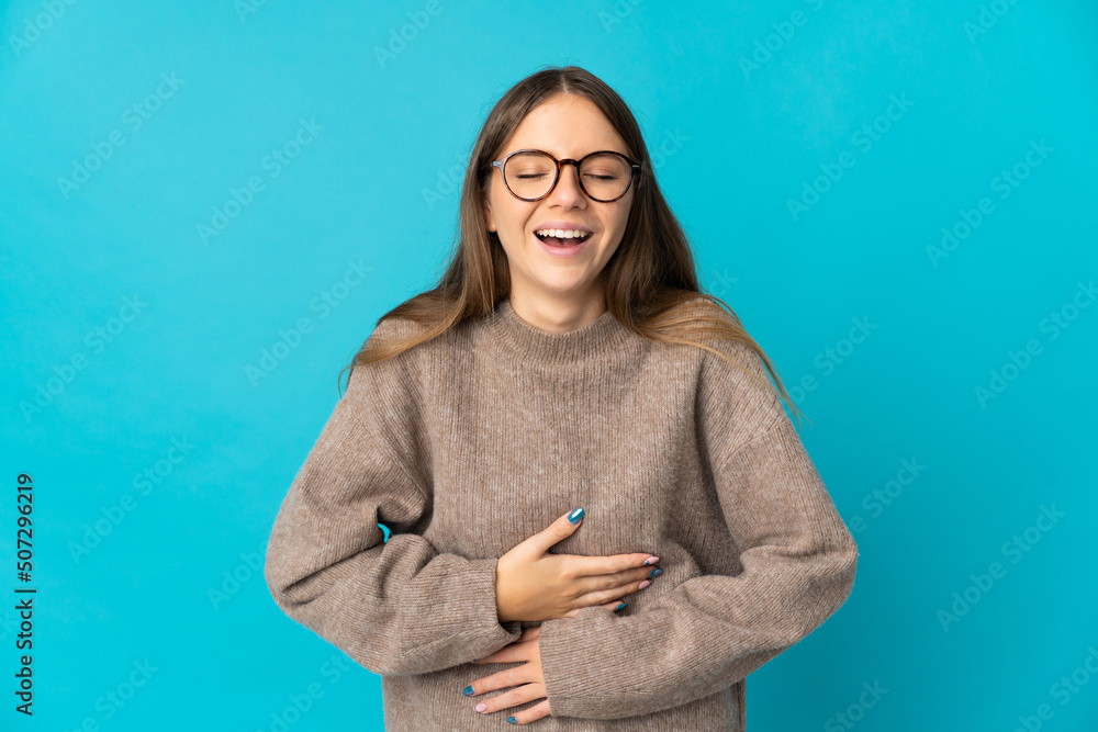 Young Lithuanian woman isolated on blue background smiling a lot Young Lithuanian woman isolated on blue background smiling a lot