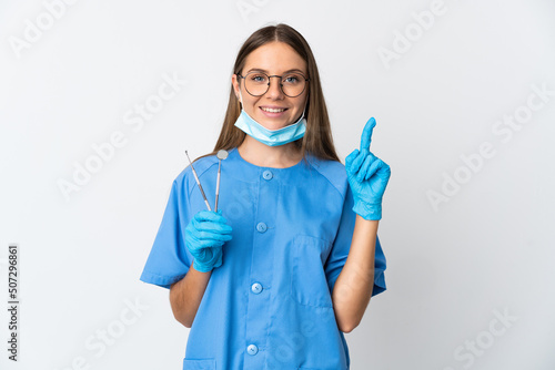Lithuanian woman dentist holding tools over isolated background pointing up a great idea