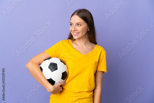 Young Lithuanian football player woman isolated on purple background looking side © luismolinero