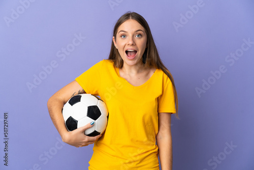 Young Lithuanian football player woman isolated on purple background with surprise facial expression © luismolinero