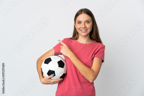 Young Lithuanian woman isolated on white background with soccer ball and pointing to the lateral © luismolinero