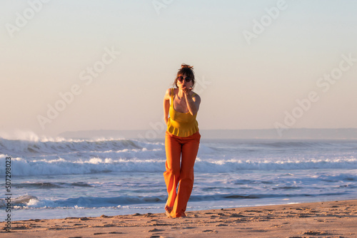 Young woman blowing kisses on the beach.