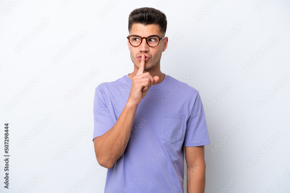 Young caucasian man isolated on white background showing a sign of silence gesture putting finger in mouth Young caucasian man isolated on white background showing a sign of silence gesture putting finger in mouth