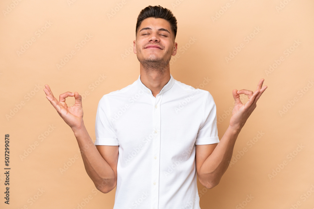 Young caucasian man isolated on beige background in zen pose Young caucasian man isolated on beige background in zen pose